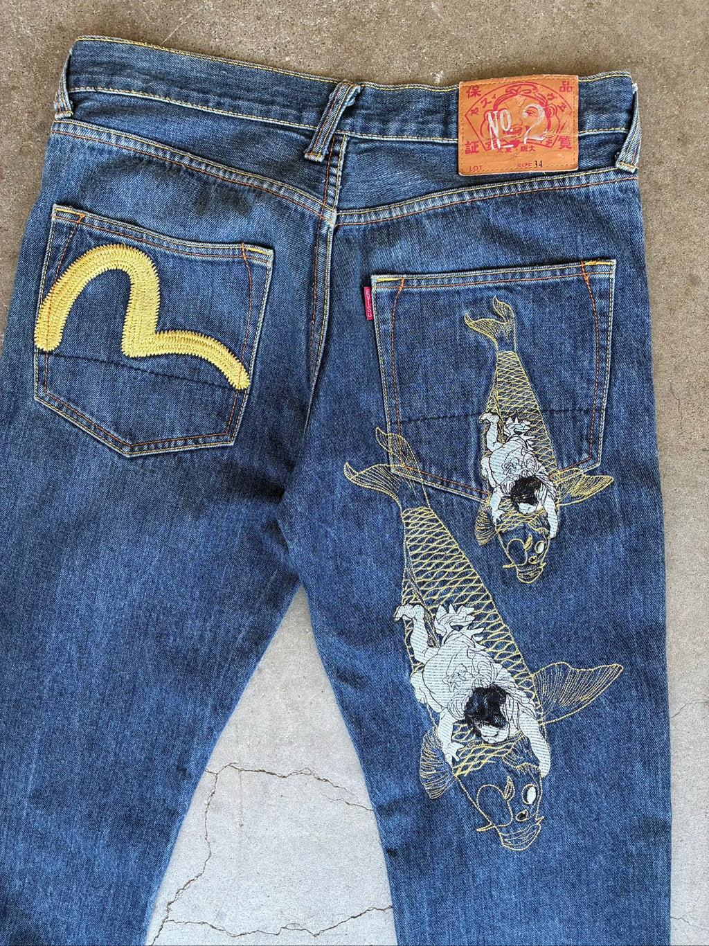 Evisu blue denim jeans with koi fish embroidery and logo, vintage Japanese style.