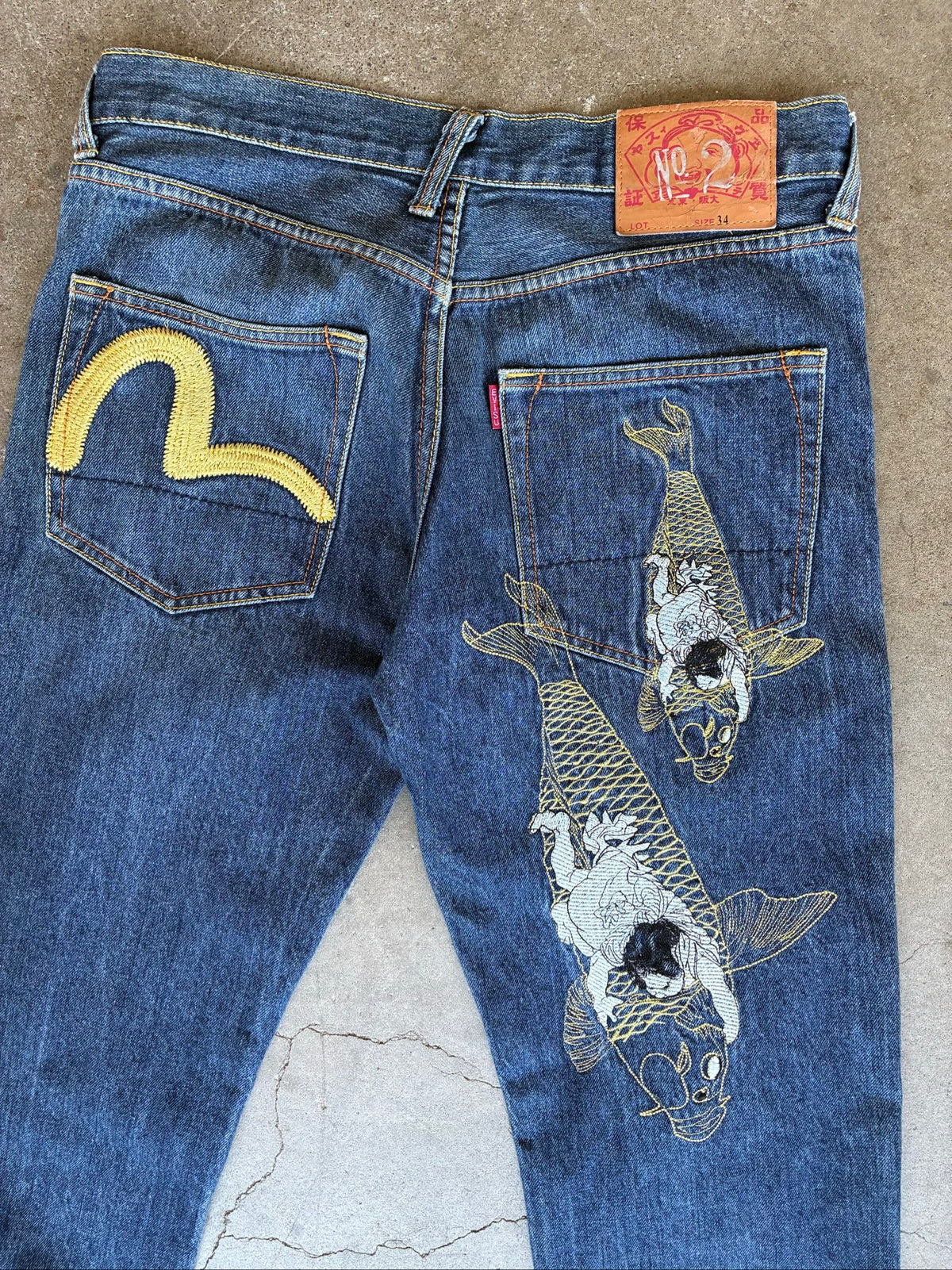Evisu blue denim jeans with koi fish embroidery and logo, vintage Japanese style.