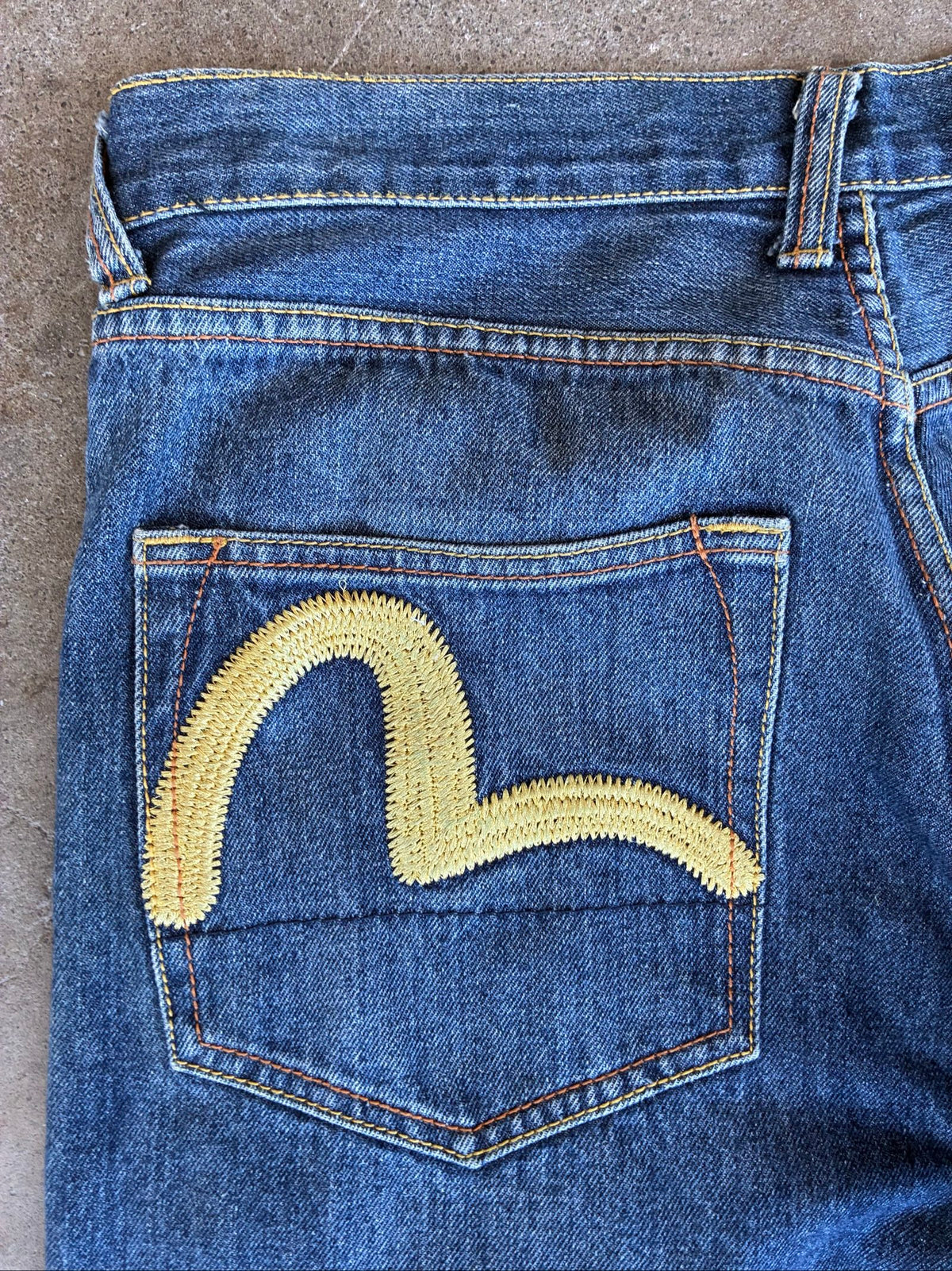Evisu blue denim jeans with koi fish embroidery and logo, vintage Japanese style.