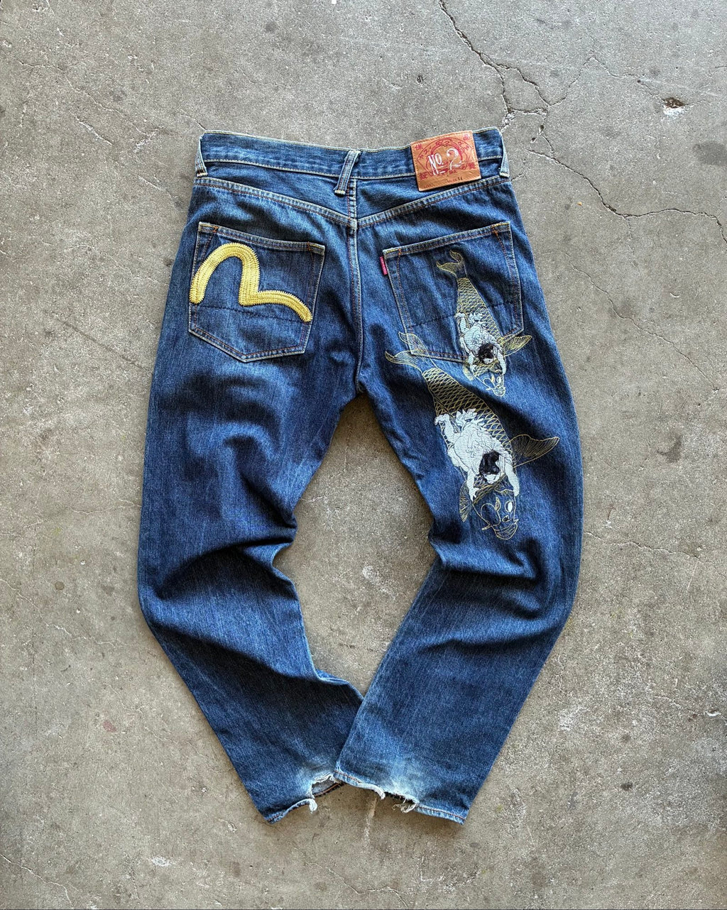 Evisu blue denim jeans with koi fish embroidery and logo, vintage Japanese style.