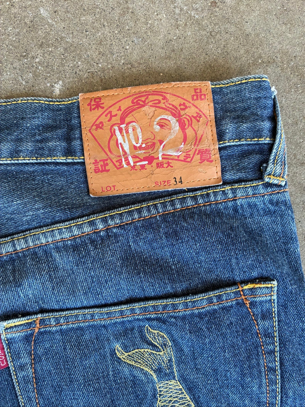 Evisu blue denim jeans with koi fish embroidery and logo, vintage Japanese style.