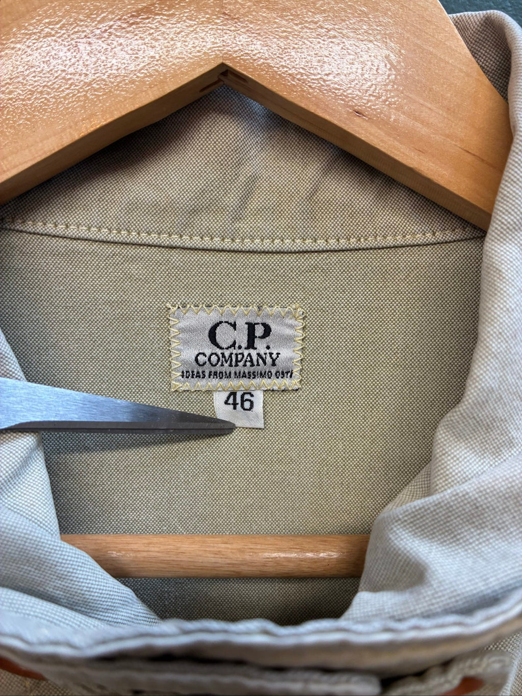C.P. Company beige cotton field jacket with mild distress and green paint marks.
