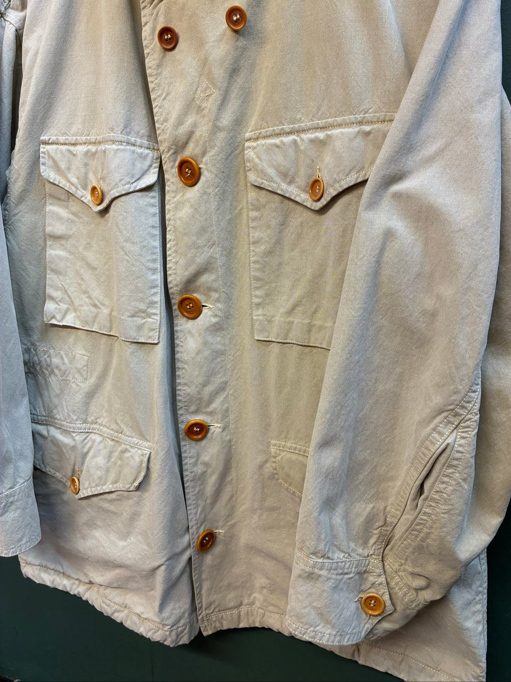 C.P. Company beige cotton field jacket with mild distress and green paint marks.