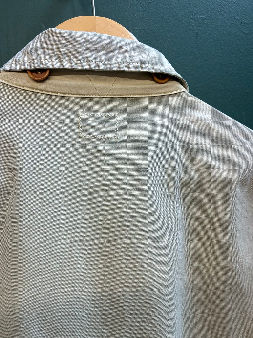 C.P. Company beige cotton field jacket with mild distress and green paint marks.