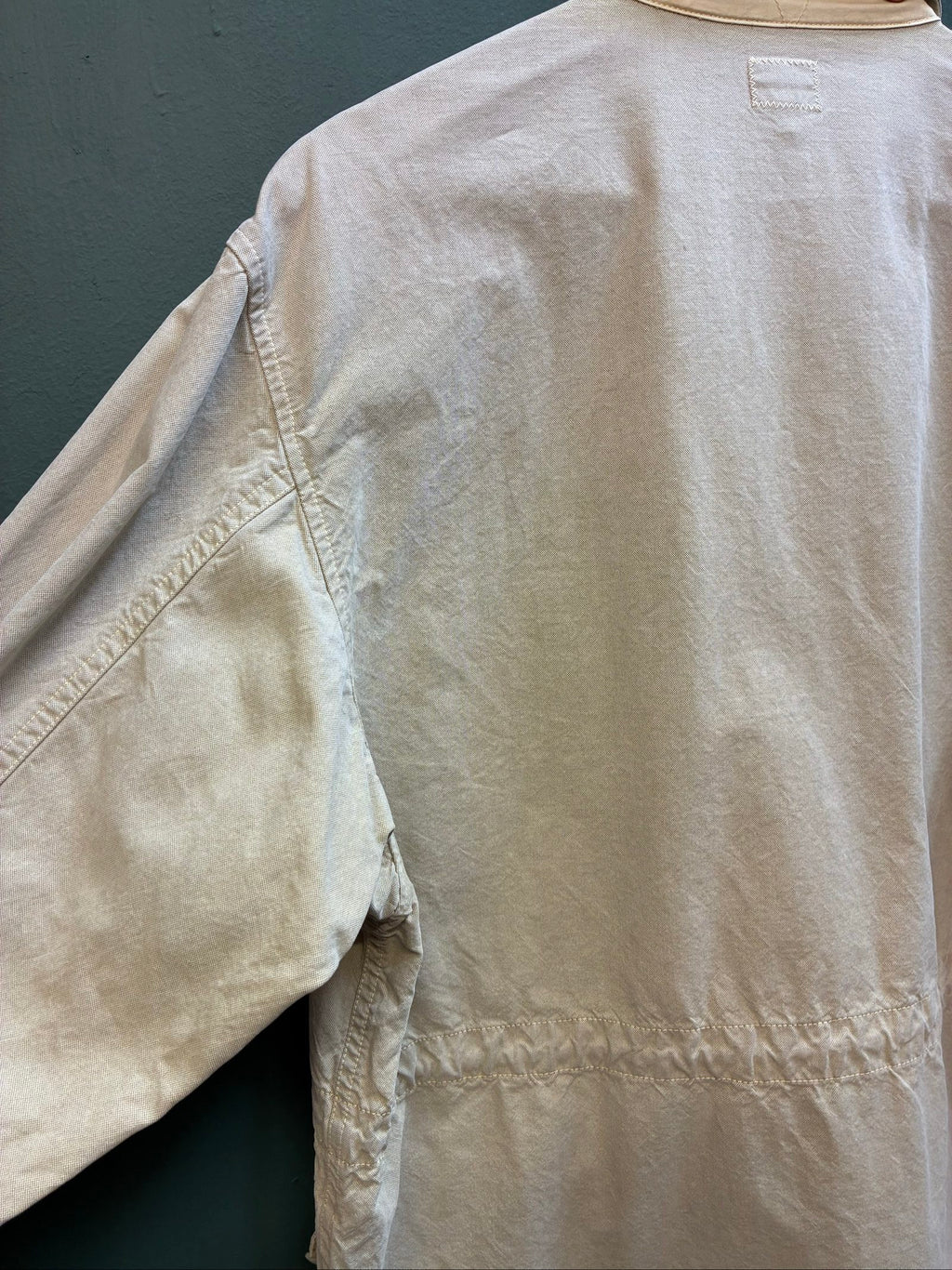 C.P. Company beige cotton field jacket with mild distress and green paint marks.