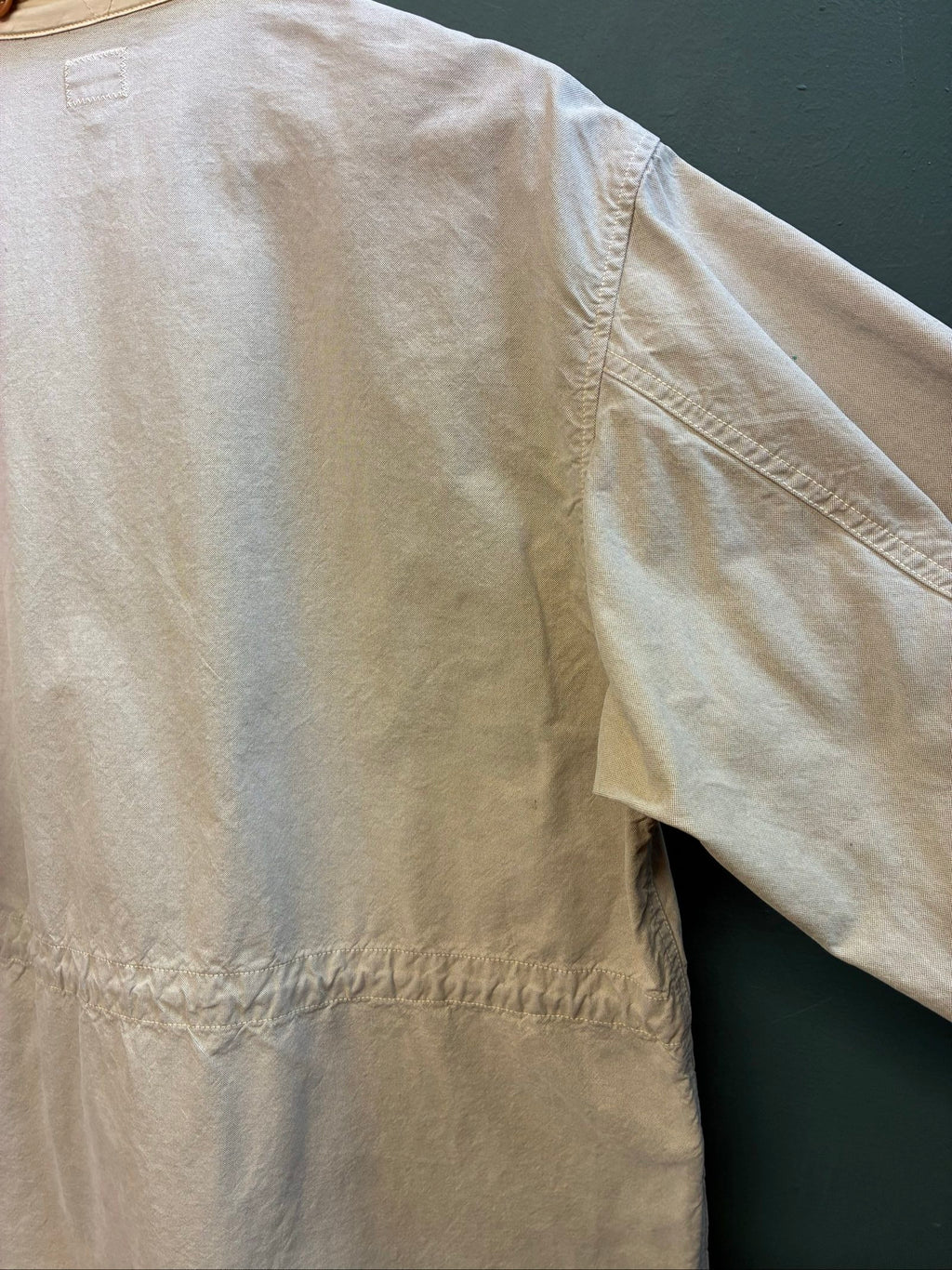 C.P. Company beige cotton field jacket with mild distress and green paint marks.