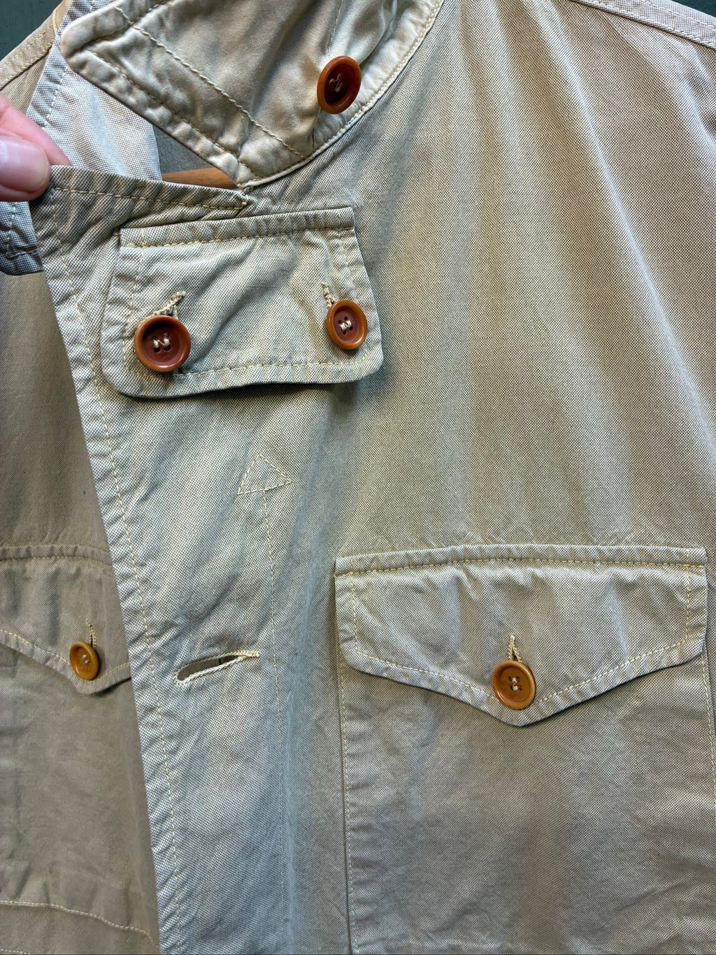 C.P. Company beige cotton field jacket with mild distress and green paint marks.