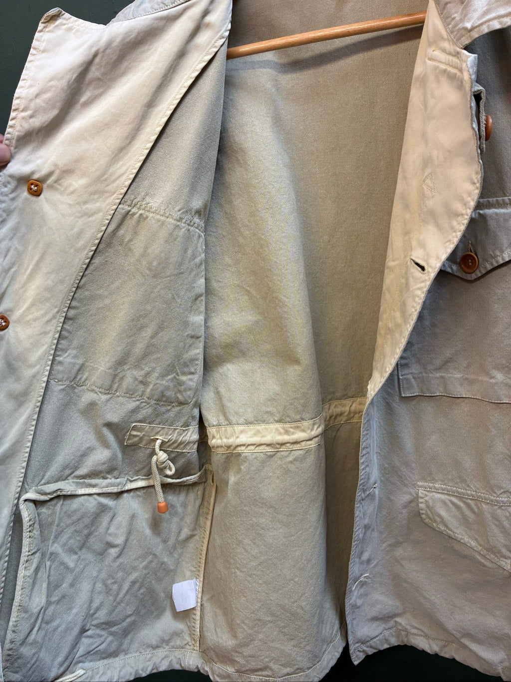 C.P. Company beige cotton field jacket with mild distress and green paint marks.