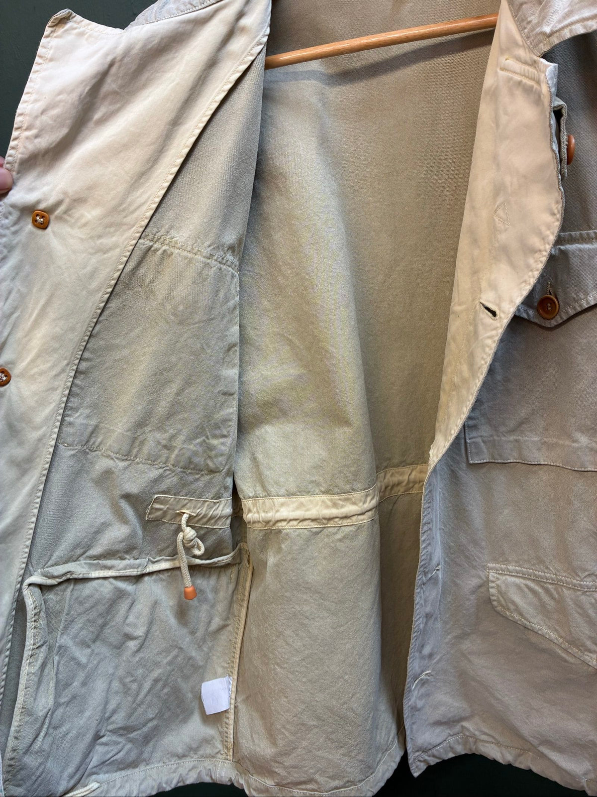 C.P. Company beige cotton field jacket with mild distress and green paint marks.