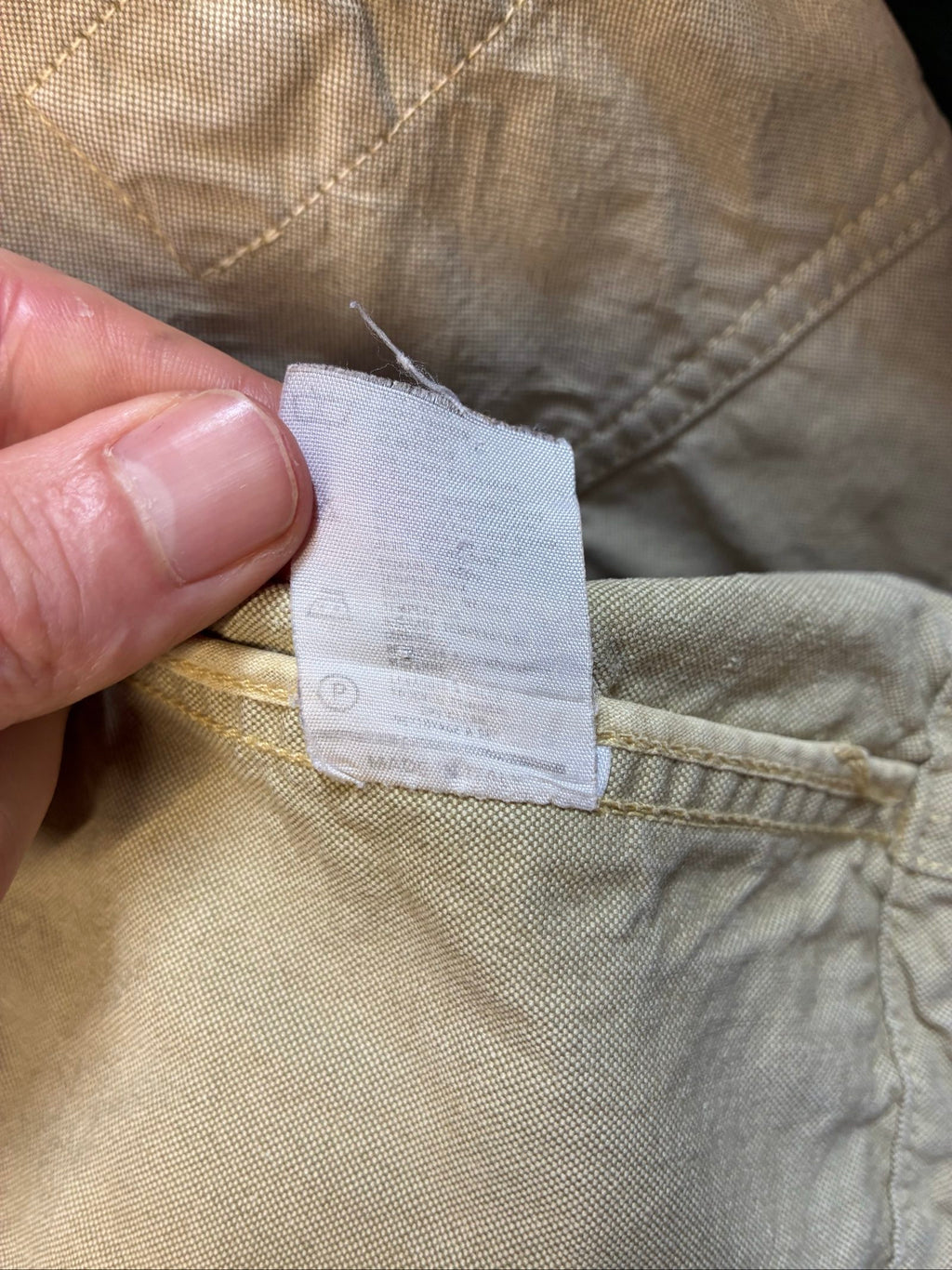 C.P. Company beige cotton field jacket with mild distress and green paint marks.