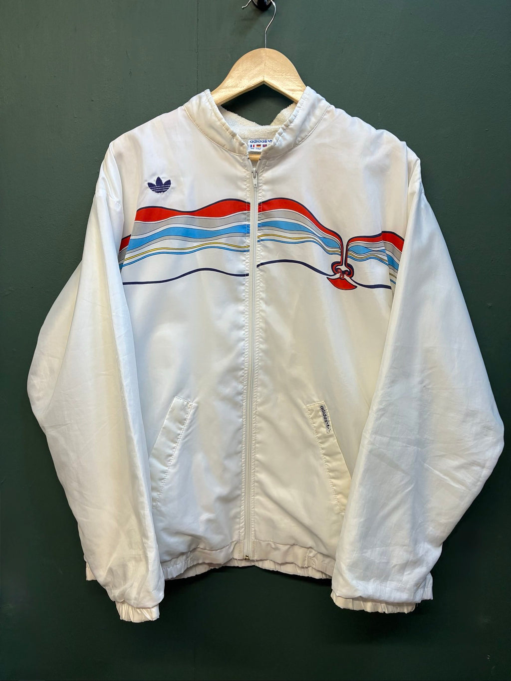 Adidas vintage blue, red, and white track jacket with logo and 80s design.