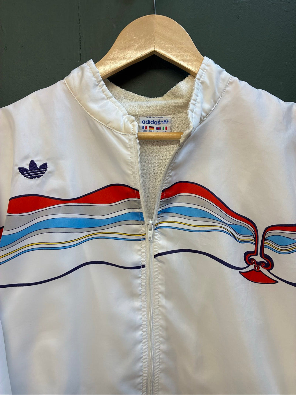 Adidas vintage blue, red, and white track jacket with logo and 80s design.