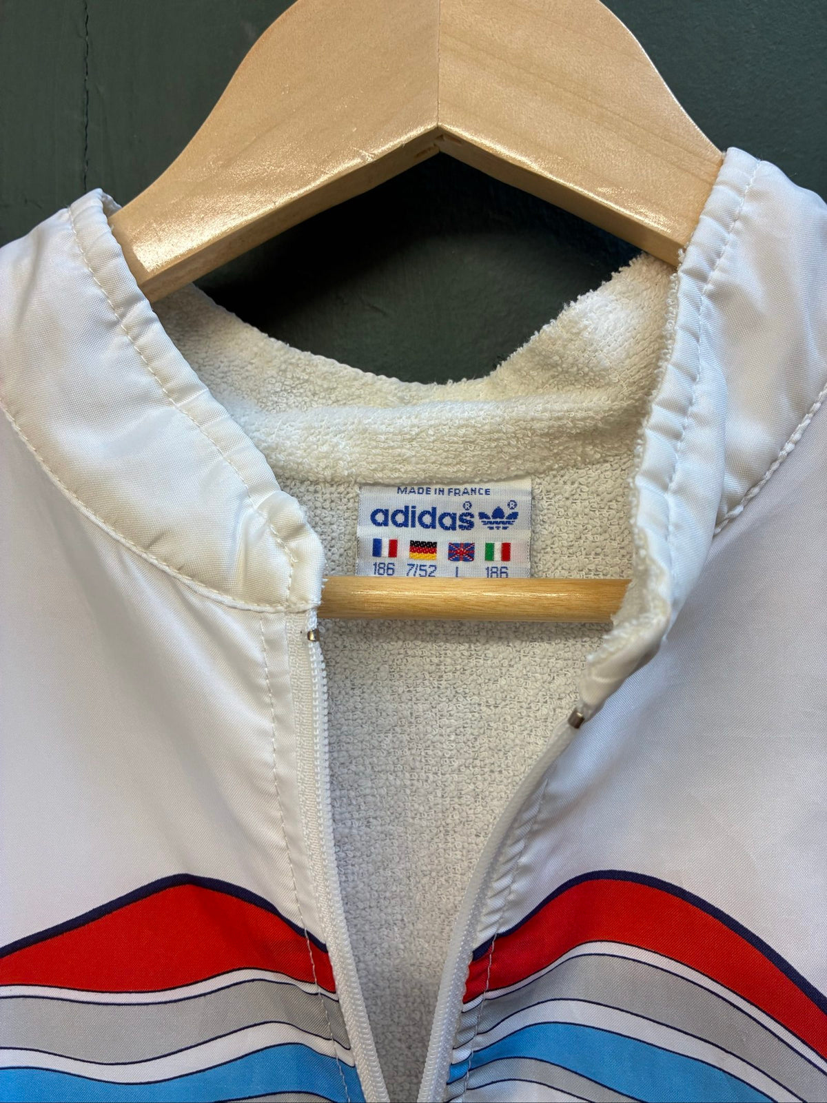 Adidas vintage blue, red, and white track jacket with logo and 80s design.