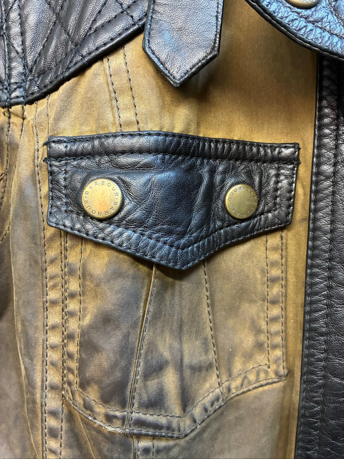 Barbour brown and black waxed cotton jacket with leather trims and gold label.