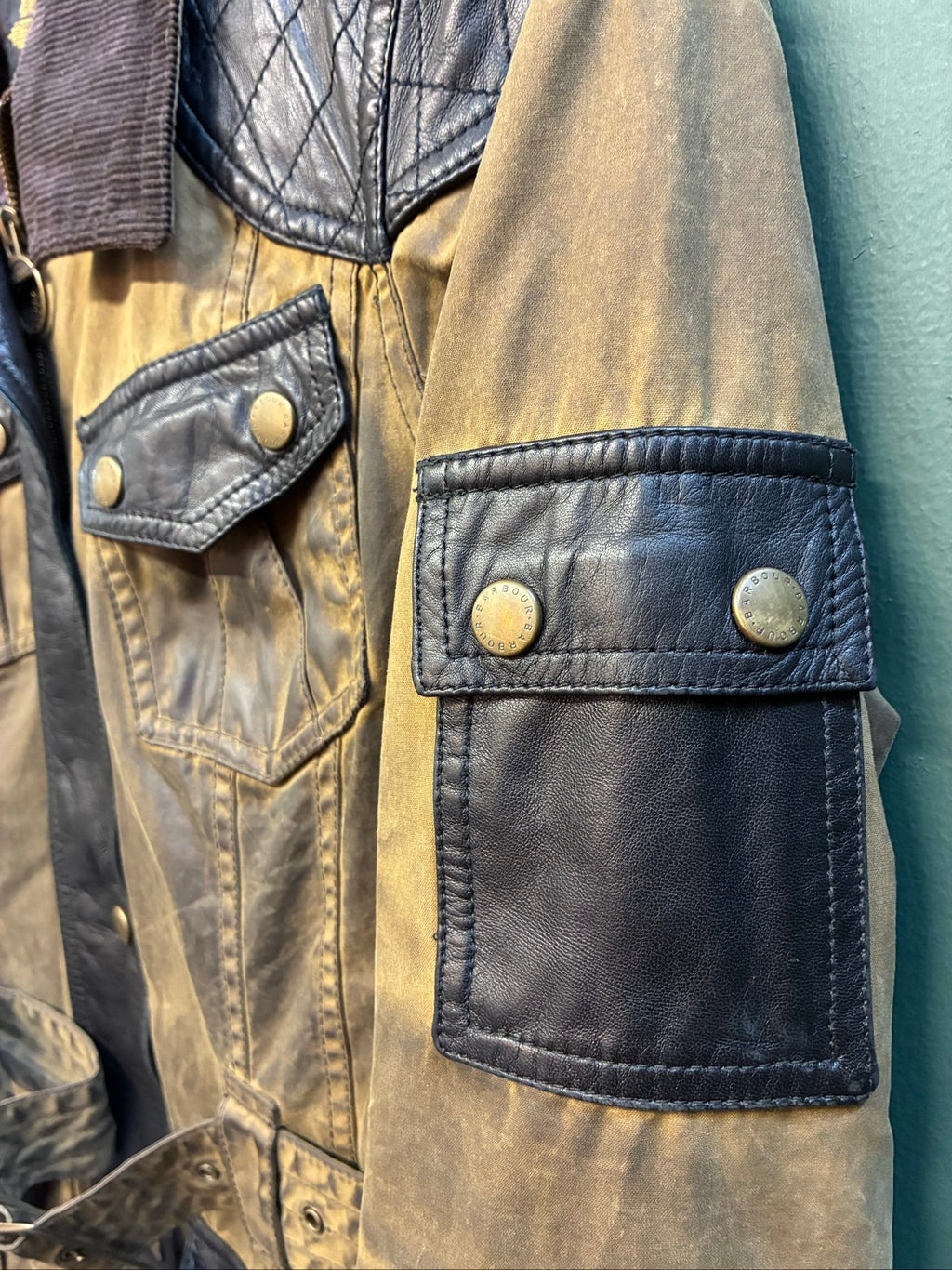 Barbour brown and black waxed cotton jacket with leather trims and gold label.
