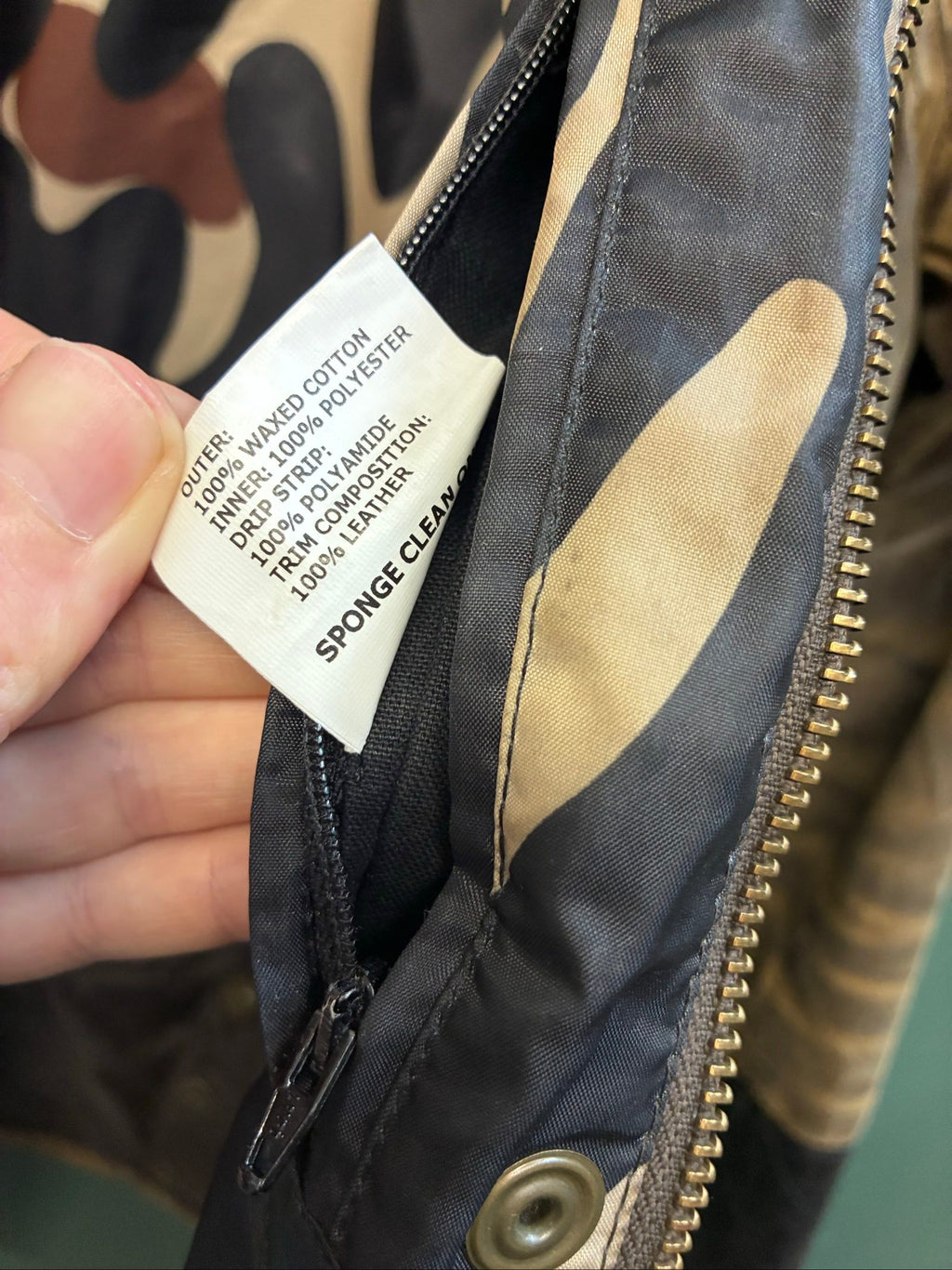 Barbour brown and black waxed cotton jacket with leather trims and gold label.