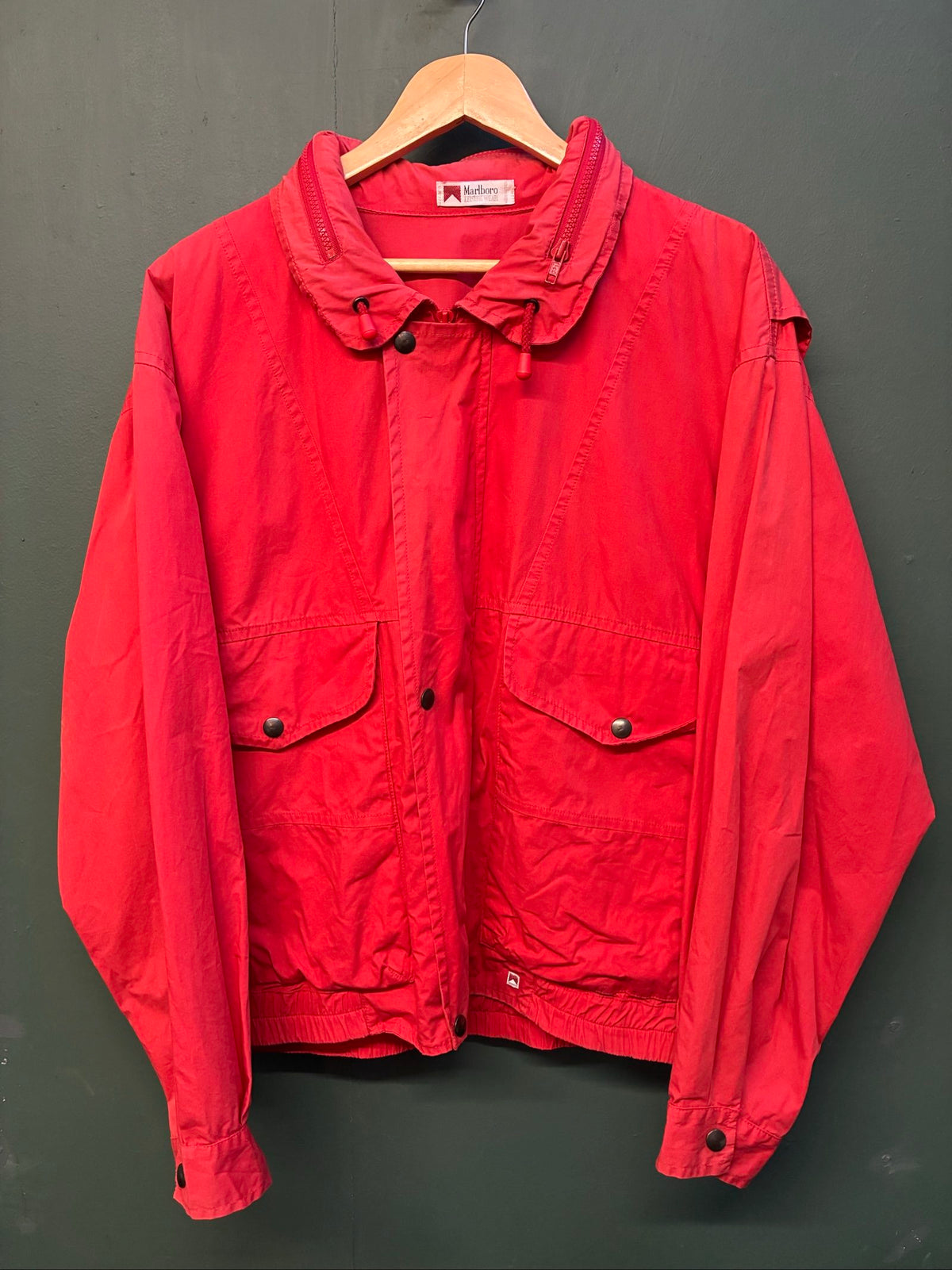 Marlboro vintage red cotton jacket with hood, snap pockets, subtle branding, 80s style.