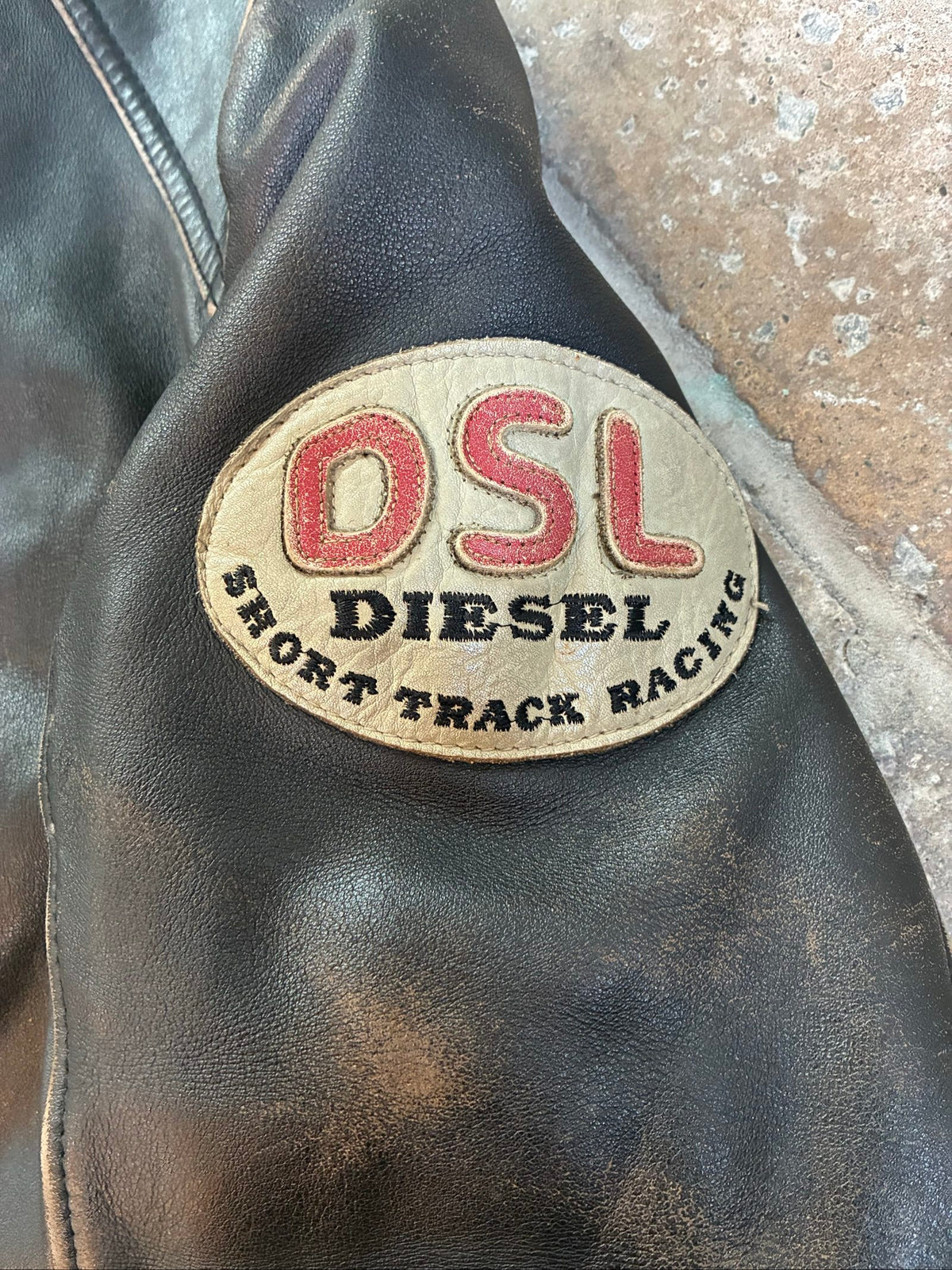 Diesel beige and black leather motorcycle jacket with quilted insulation and zipper pockets.