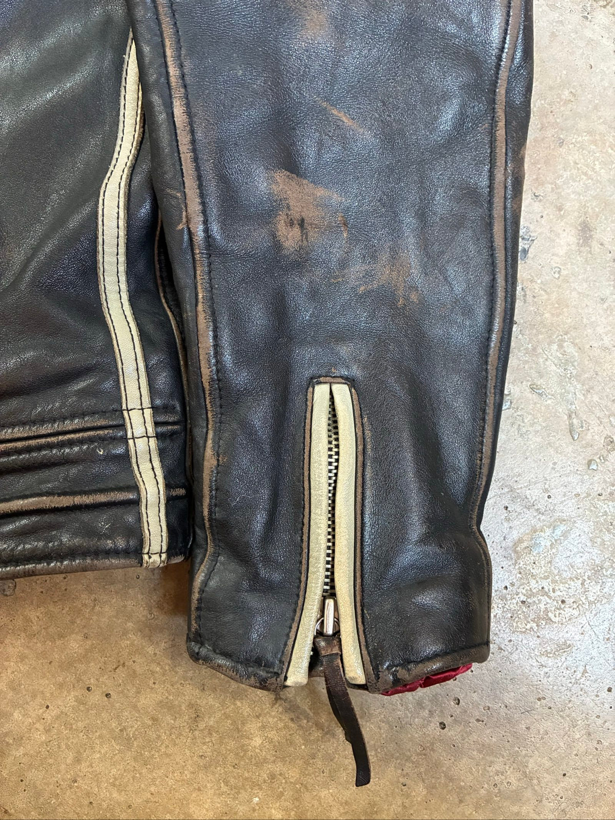 Diesel beige and black leather motorcycle jacket with quilted insulation and zipper pockets.