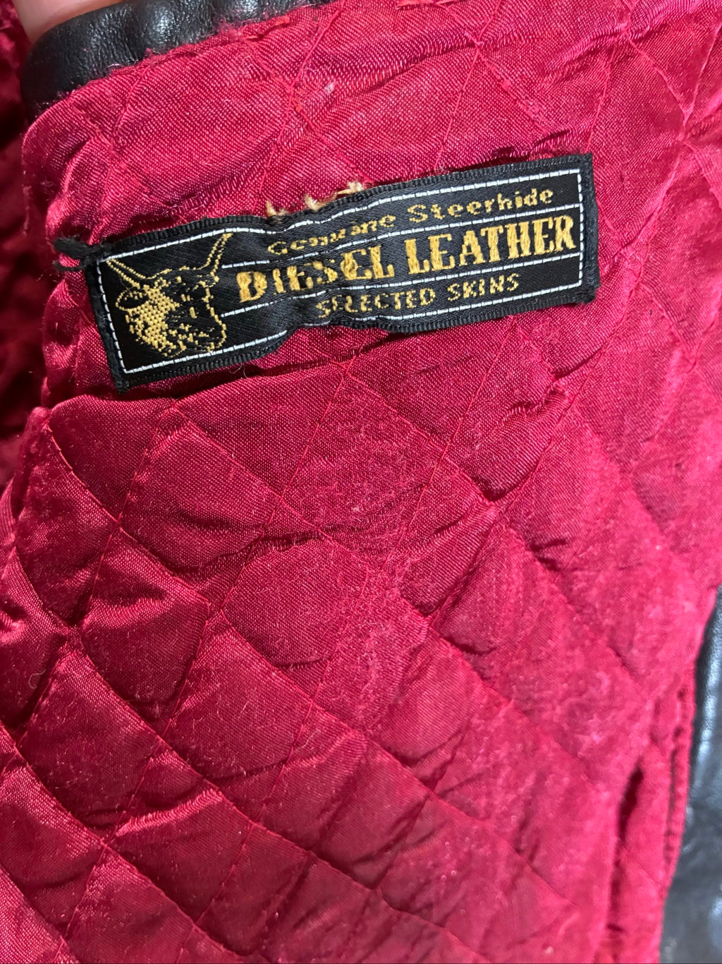 Diesel beige and black leather motorcycle jacket with quilted insulation and zipper pockets.