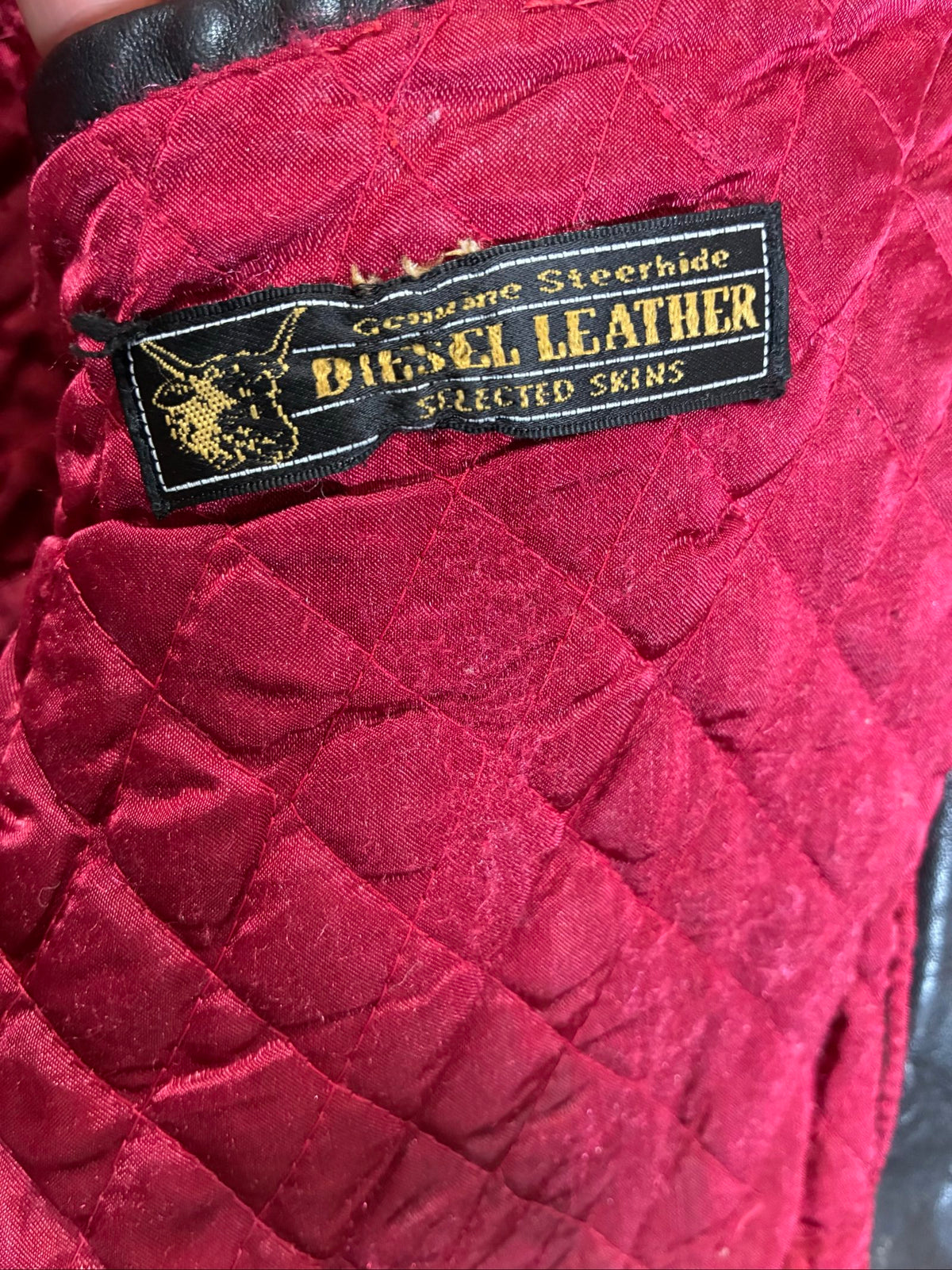 Diesel beige and black leather motorcycle jacket with quilted insulation and zipper pockets.