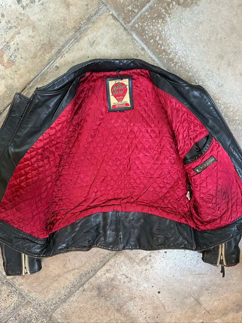 Diesel beige and black leather motorcycle jacket with quilted insulation and zipper pockets.