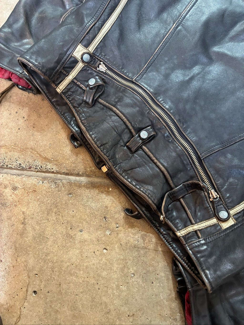 Diesel beige and black leather motorcycle jacket with quilted insulation and zipper pockets.
