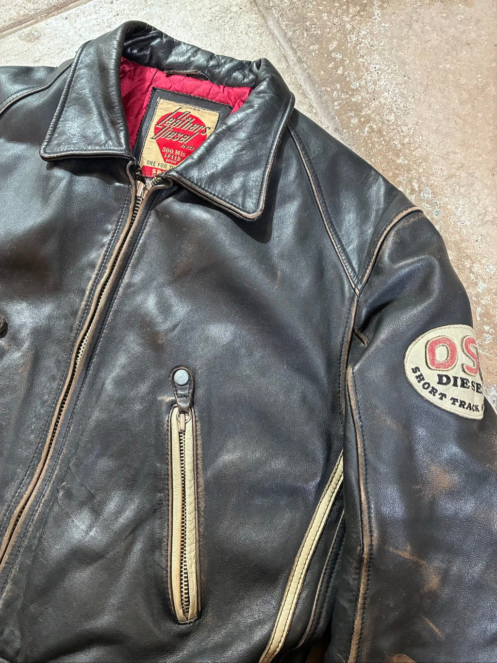 Diesel beige and black leather motorcycle jacket with quilted insulation and zipper pockets.