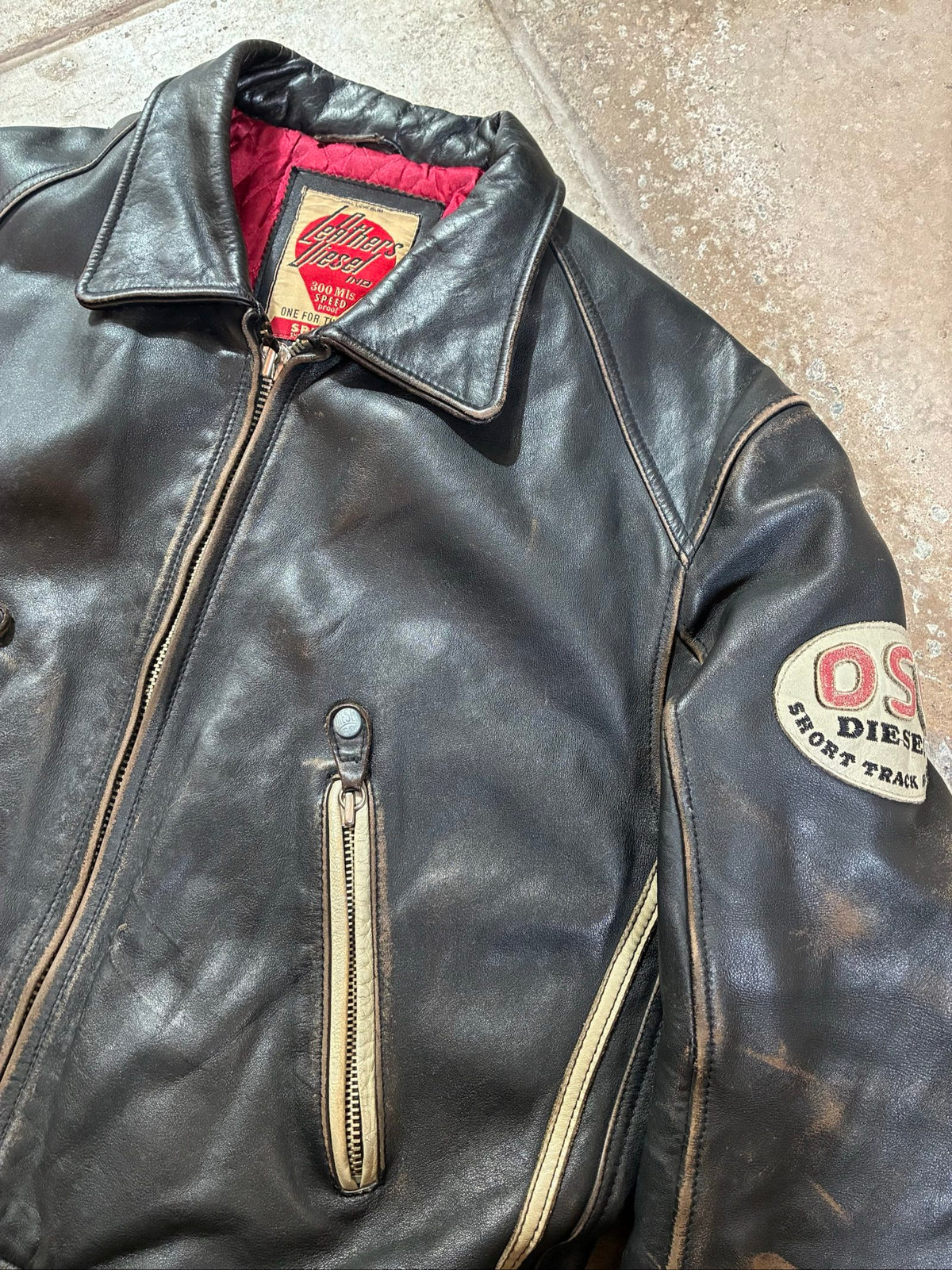 Diesel beige and black leather motorcycle jacket with quilted insulation and zipper pockets.