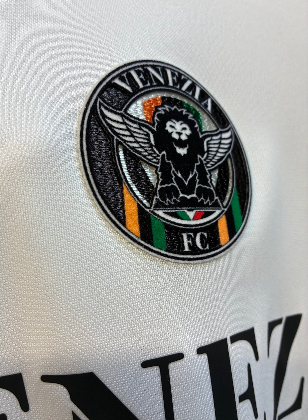 Nike football shirt white with raised Venezia logos, black and green accents.