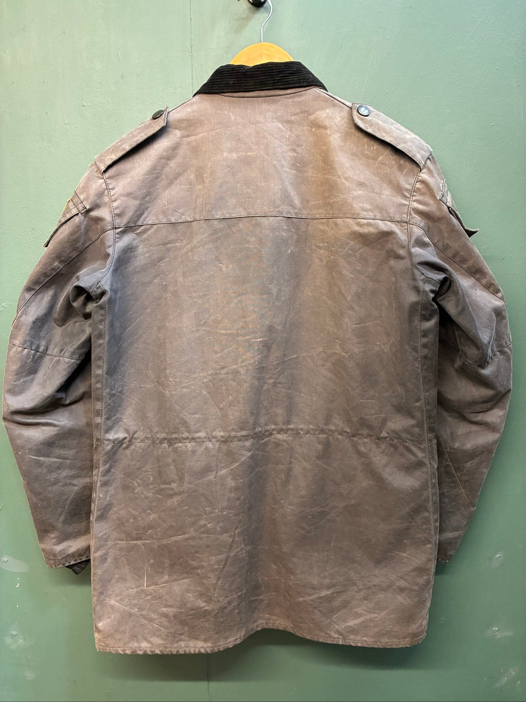Barbour black and grey wax jacket with military utility design and made in England tag.