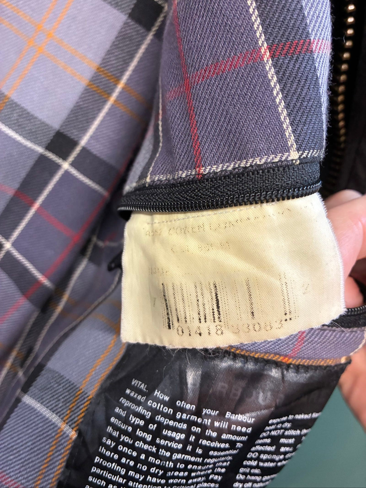 Barbour black and grey wax jacket with military utility design and made in England tag.