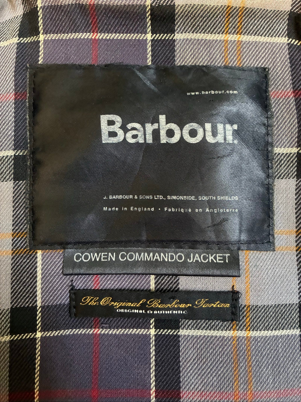 Barbour black and grey wax jacket with military utility design and made in England tag.