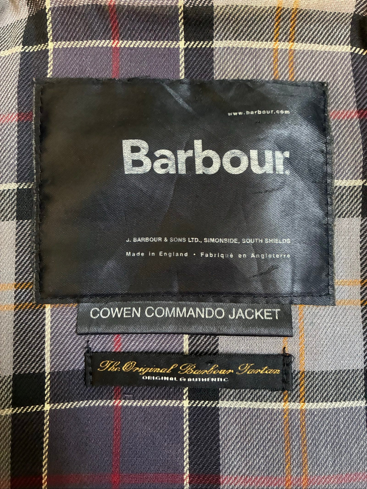 Barbour black and grey wax jacket with military utility design and made in England tag.