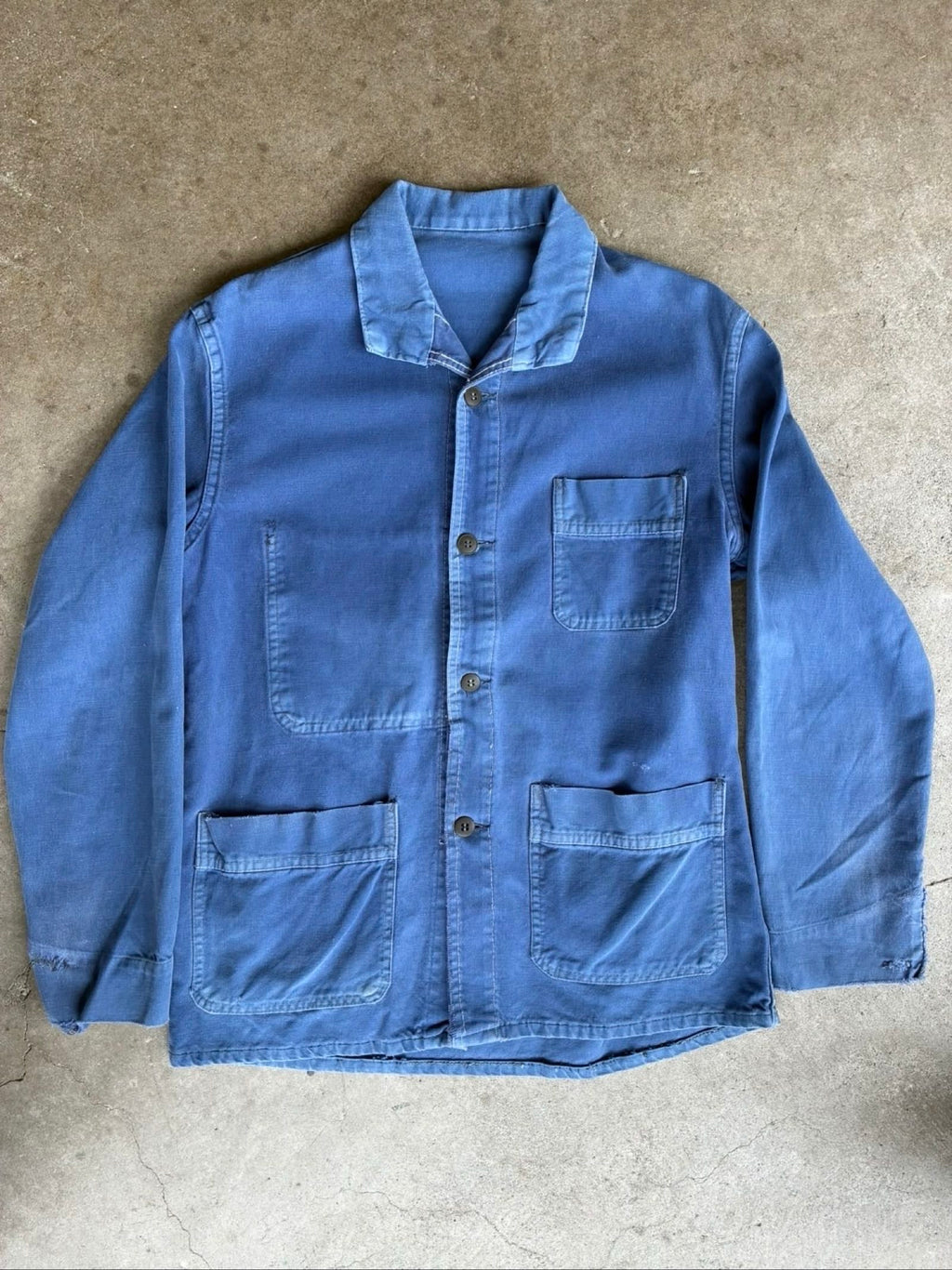 Vintage blue moleskin workwear jacket with distressed texture and no labels.