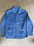 Vintage blue moleskin workwear jacket with distressed texture and no labels.