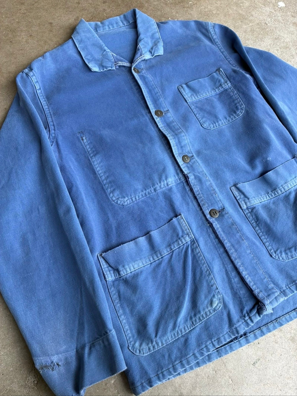 Vintage blue moleskin workwear jacket with distressed texture and no labels.