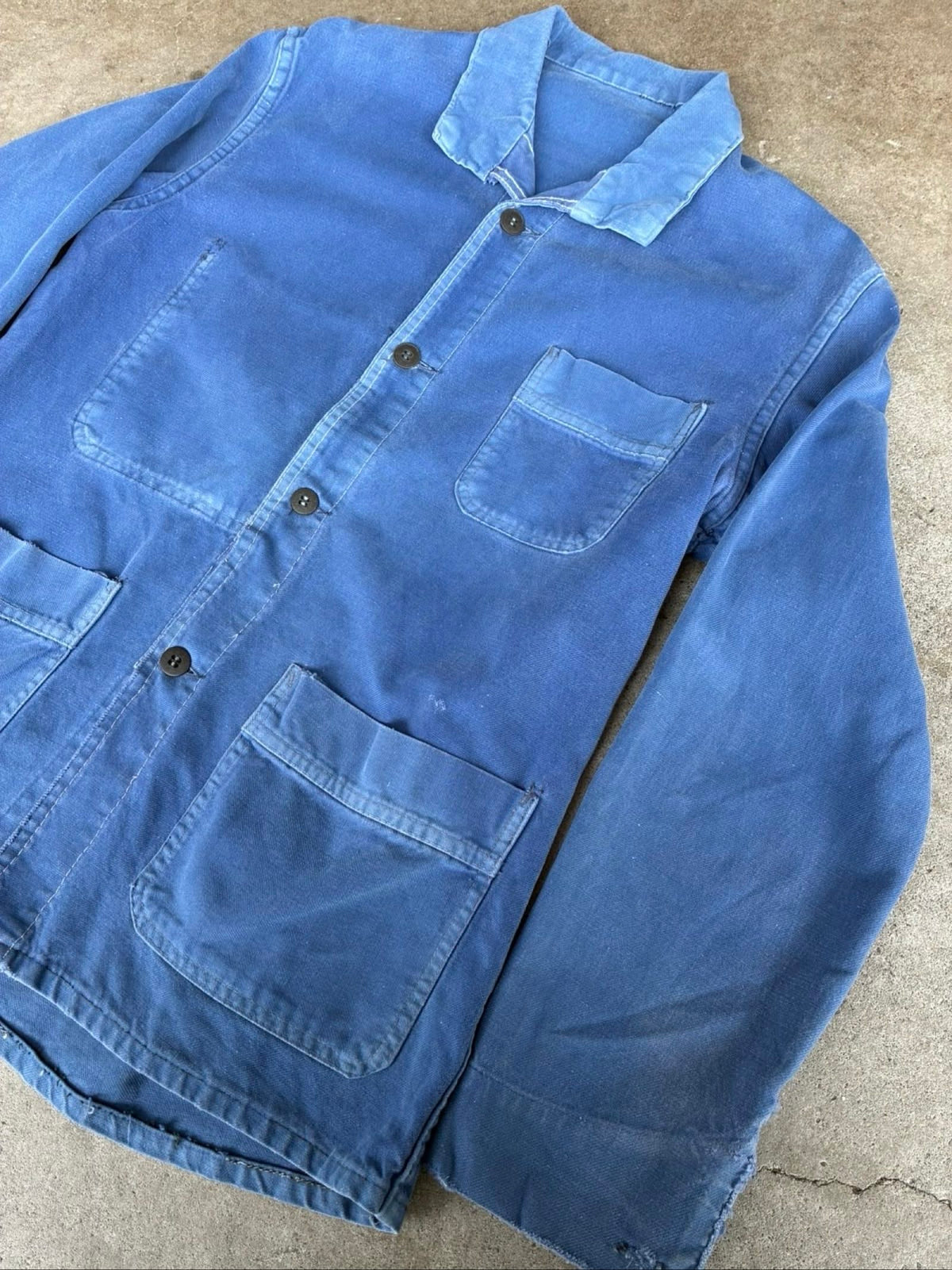 Vintage blue moleskin workwear jacket with distressed texture and no labels.