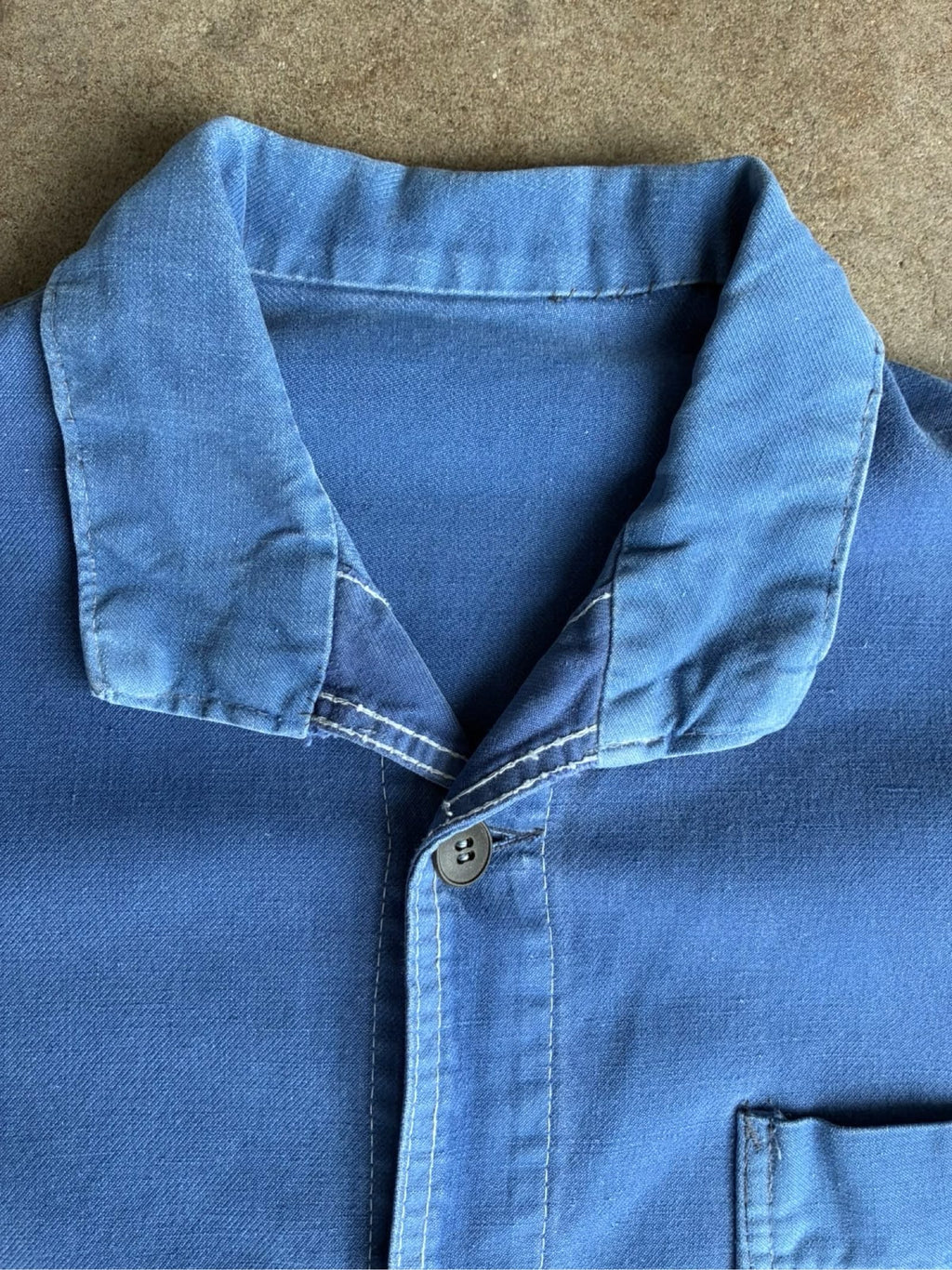 Vintage blue moleskin workwear jacket with distressed texture and no labels.