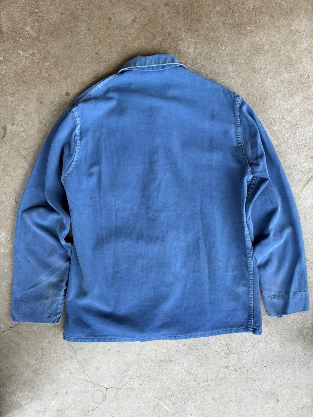 Vintage blue moleskin workwear jacket with distressed texture and no labels.