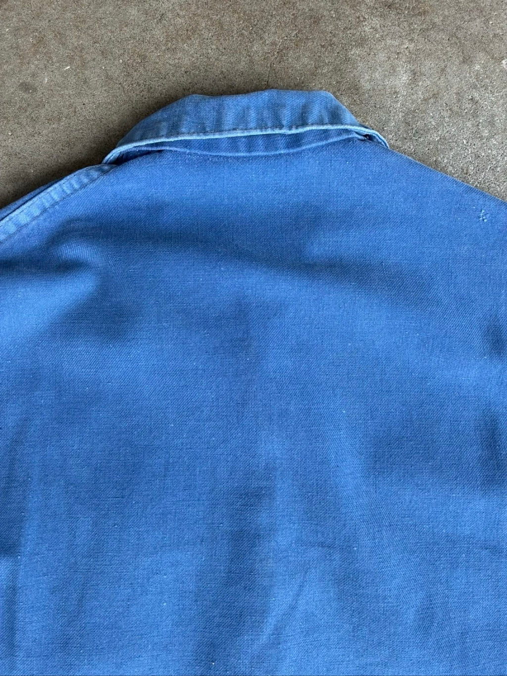 Vintage blue moleskin workwear jacket with distressed texture and no labels.